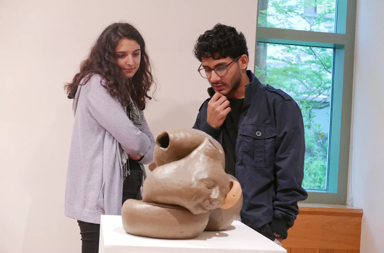Two students examine sculpture