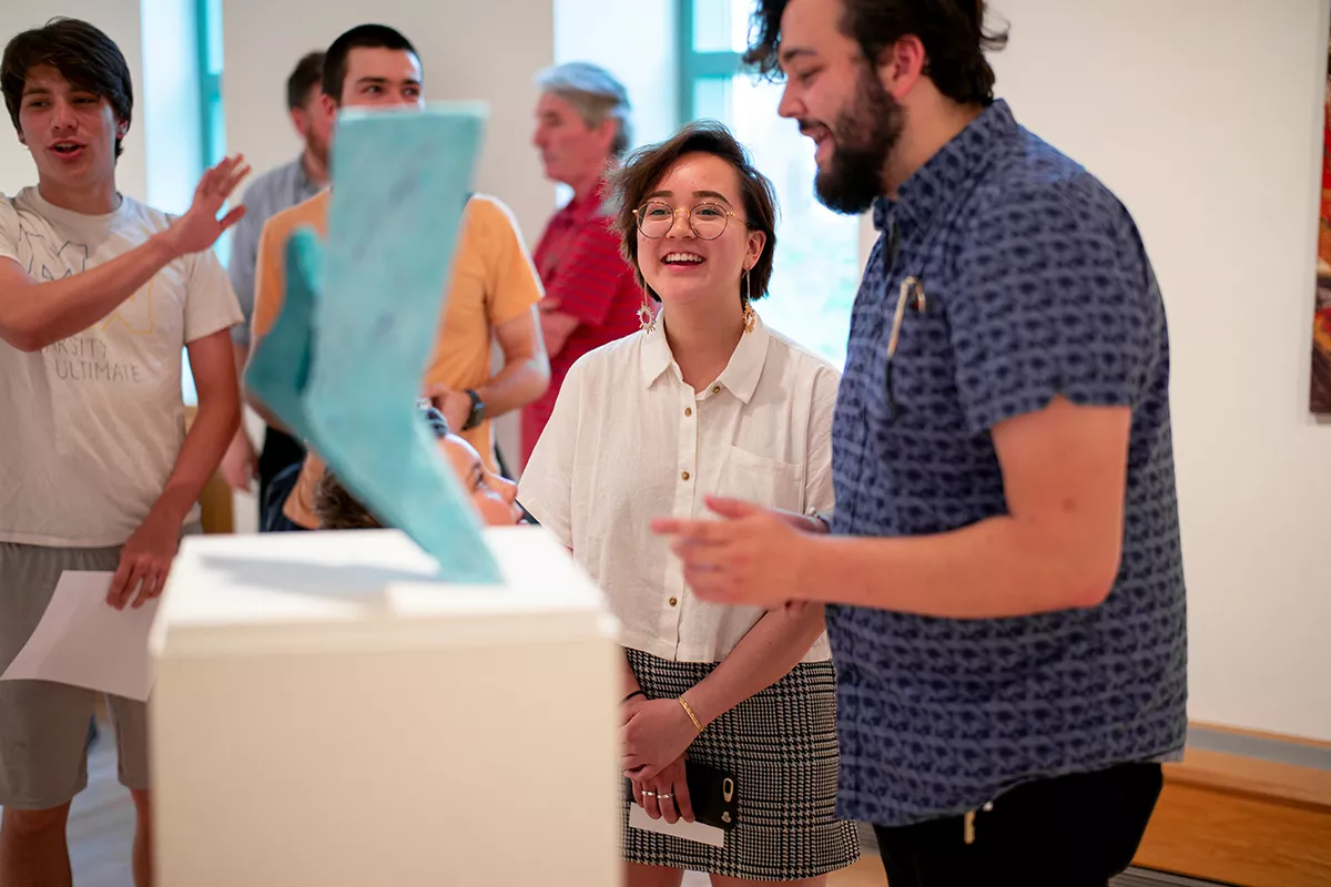 Students examine blue sculpture in List Gallery