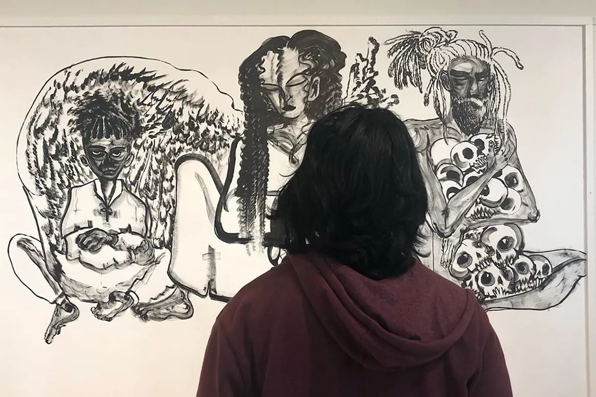 Person views black and white drawing in gallery