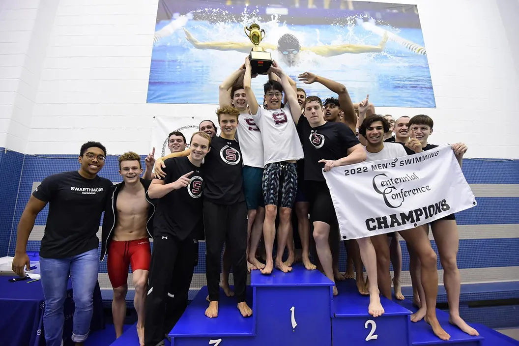Men's swimming team with trophy