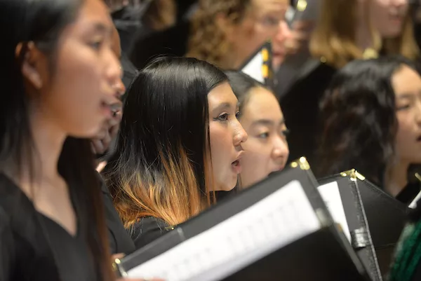 group of students singing on stage