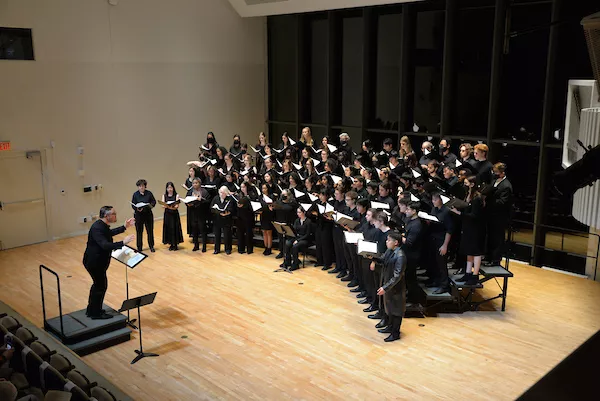Swarthmore Chorus on stage at the 2023 winter concert with director Nathan Reiff.