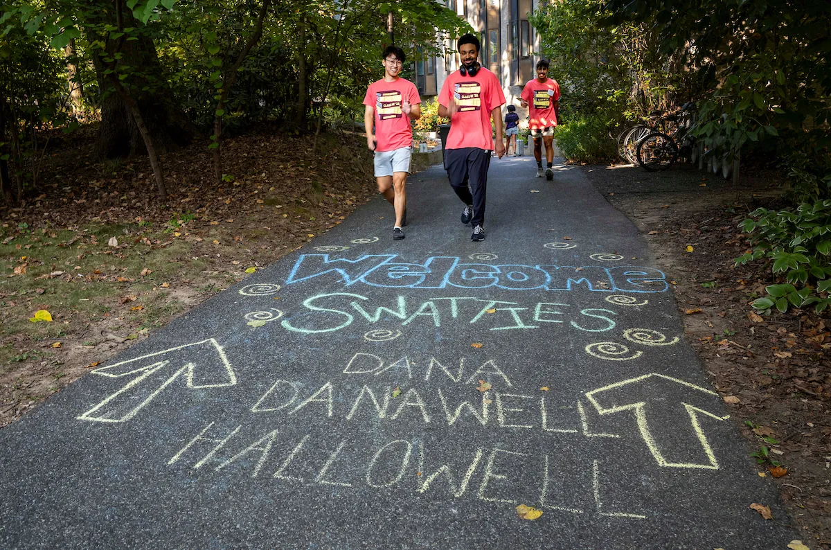 Chalk writing on pavement directs students to Swarthmore campus dorms