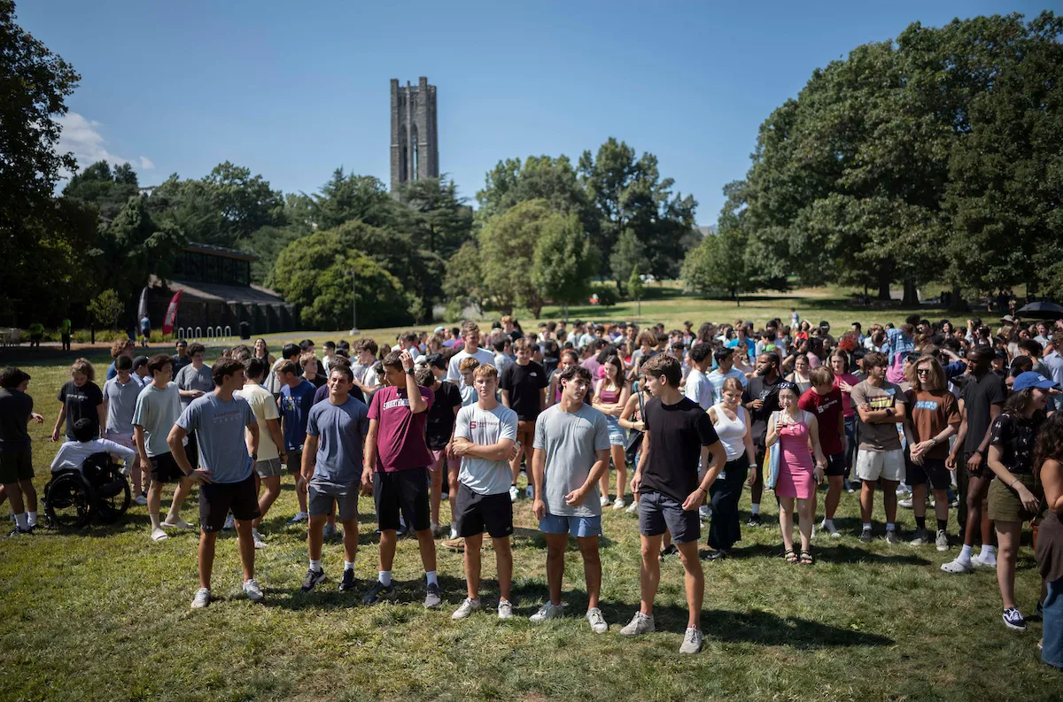 Class of 2028 students gather on grass during orientation