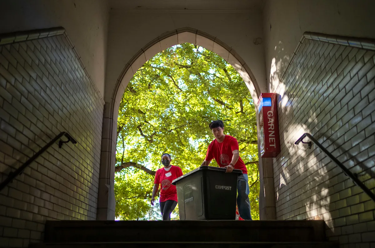 Orientation members move items during move-in with Wharton Hall courtyard in background