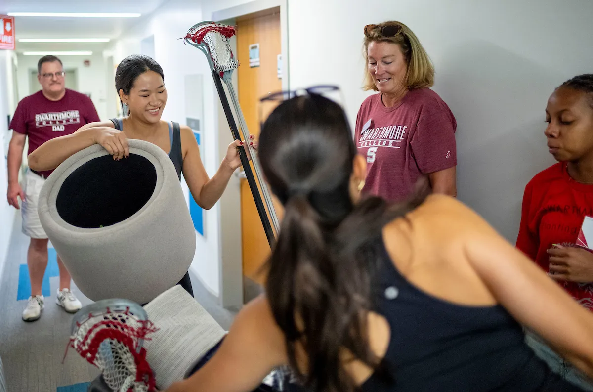 Student in room with lacrosse sticks during move-in
