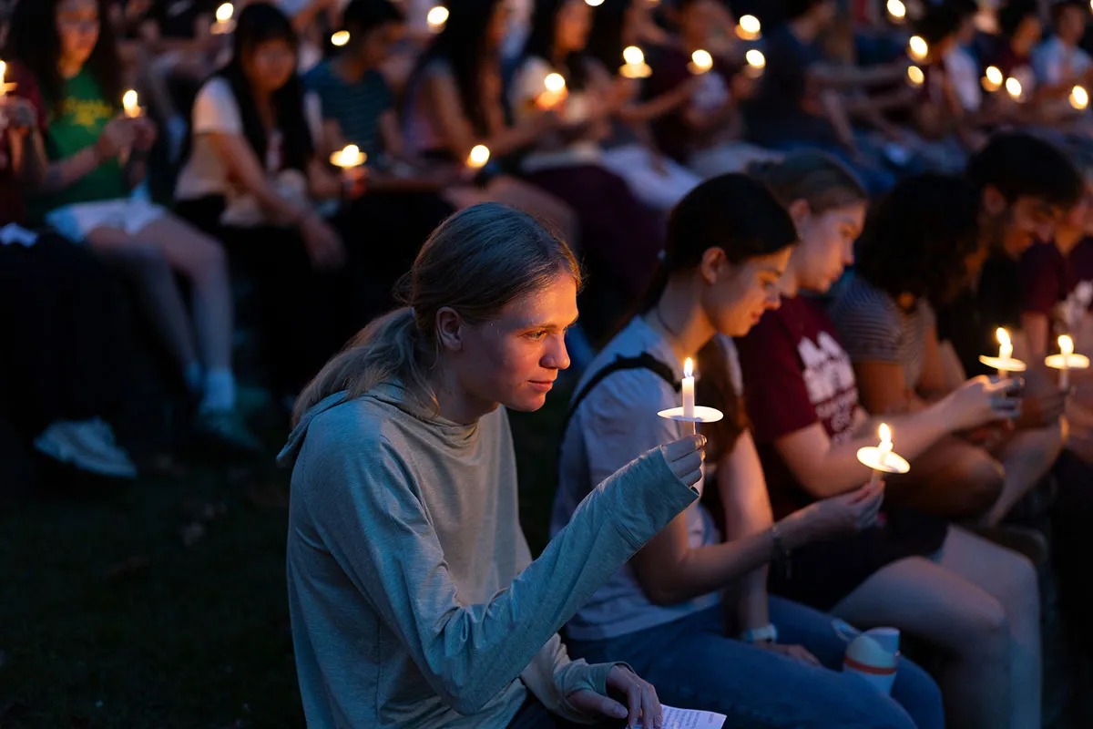 Students hold candles at first collection in Scott Outdoor amphitheater