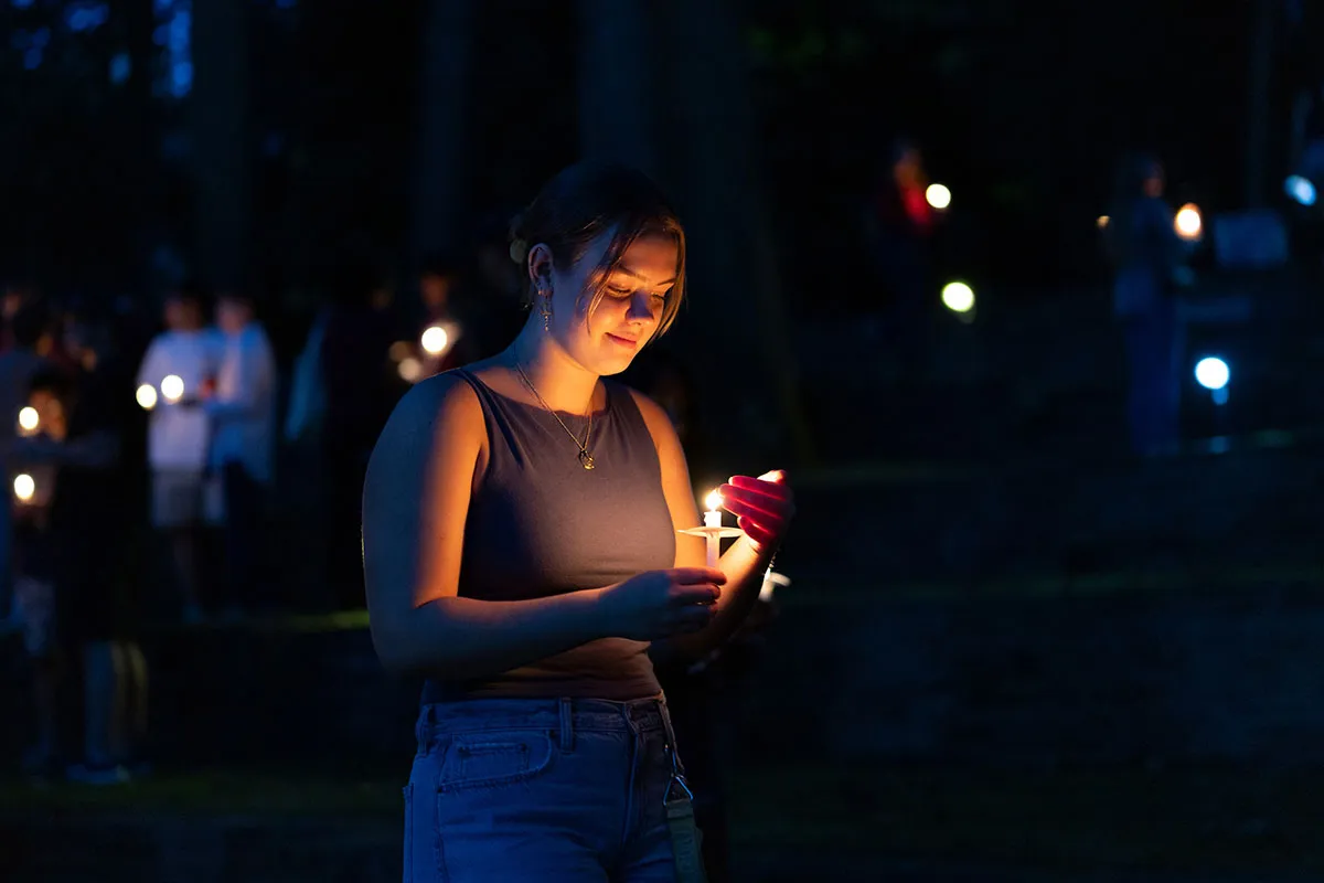 Student holds candle at first collection in Scott Outdoor amphitheater
