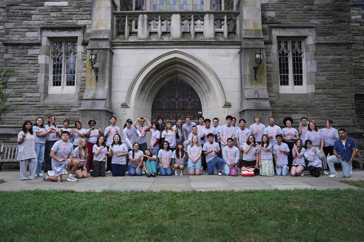 FLI students pose for group photo outside clothier belltower
