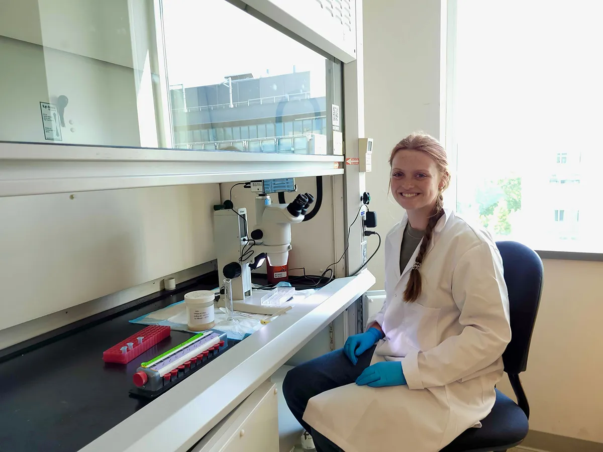 Lane Barron in lab looking at microscope
