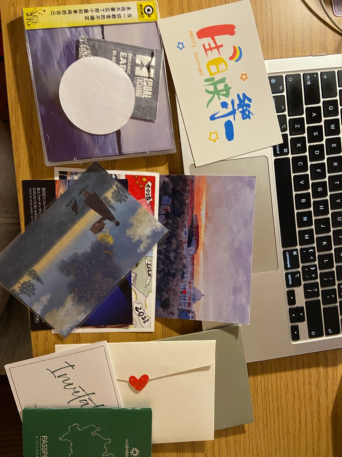 cards and letters spread out on top of a desk with a laptop