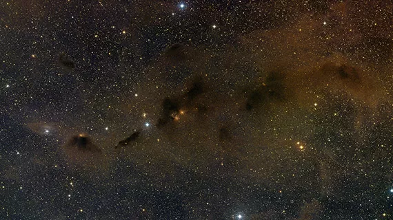 This wide field image shows extensive dust and small clumps of star formation in part of the Taurus star formation region. A faint star at the centre of this picture is the young binary star system HK Tauri. ALMA observations of this system have provided the clearest picture ever of protoplanetary discs in a double star.
