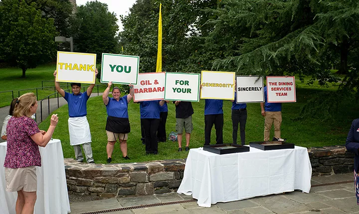 Dining Service workers hold up placards