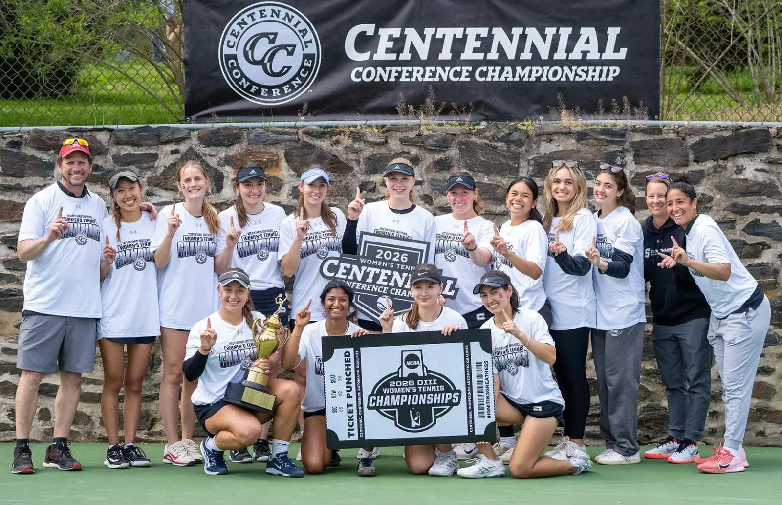 women's tennis team on court with trophy and "ticket" to NCAA tournament