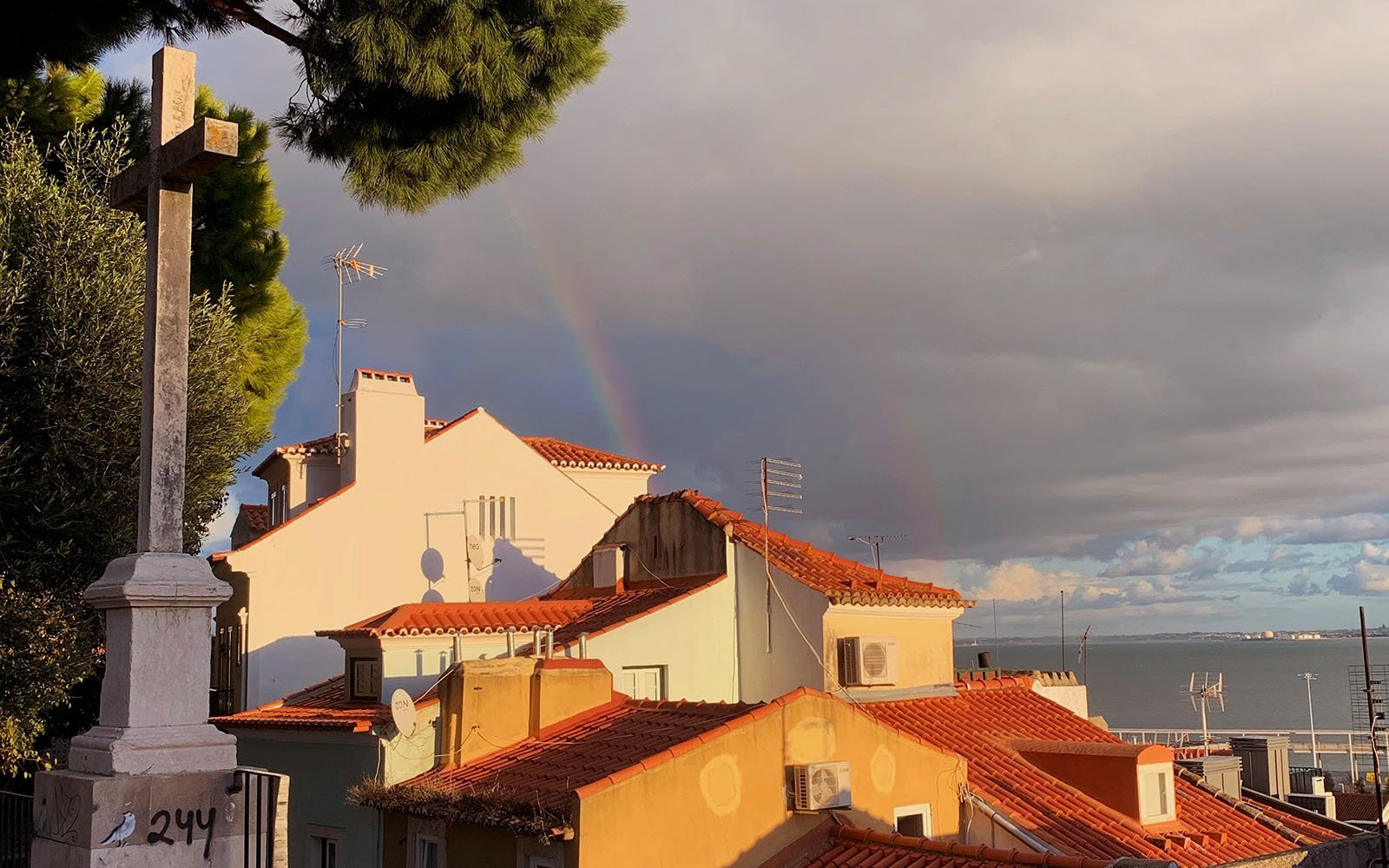 rooftops with dramatic sky and rainbow