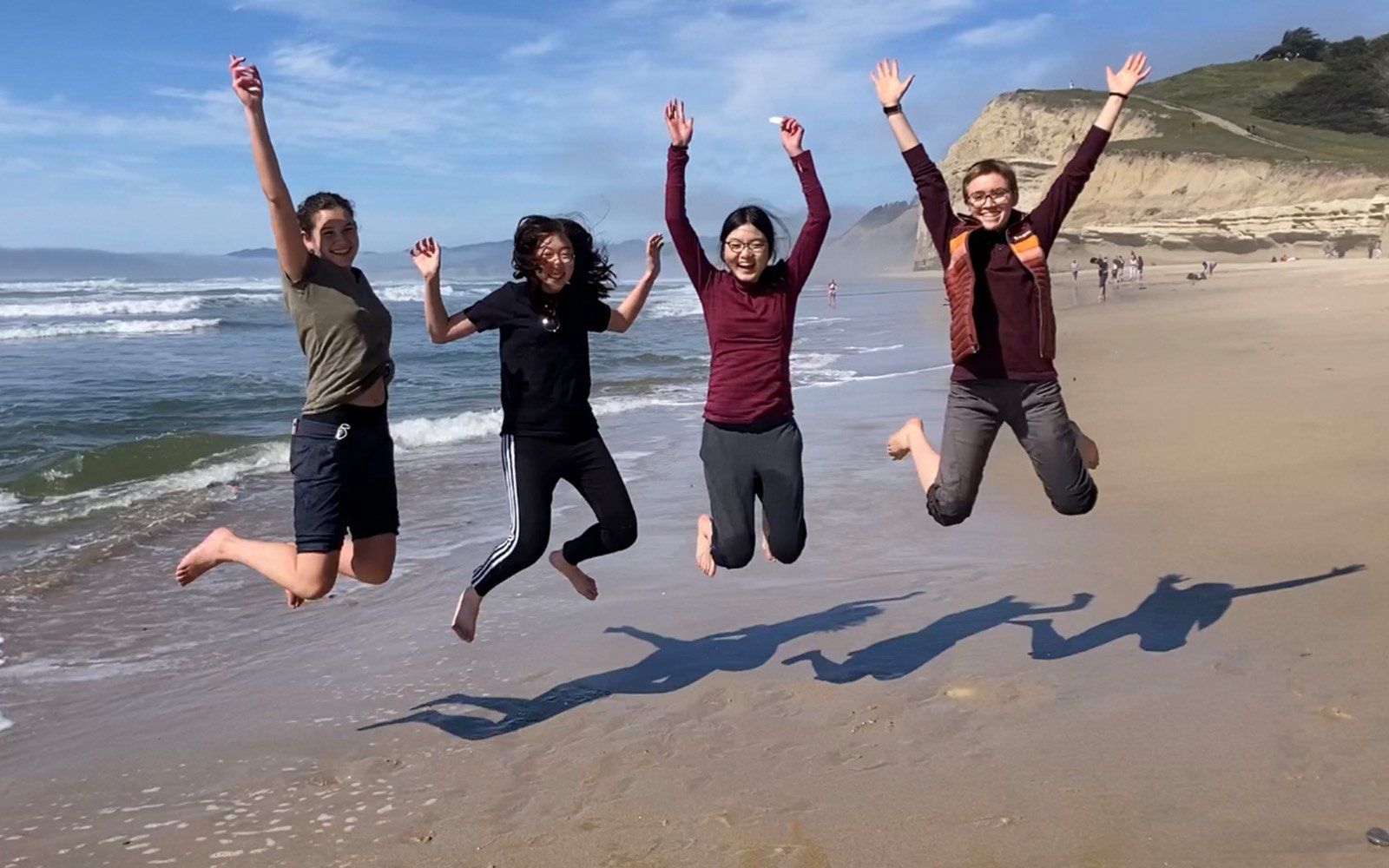 Students jumping at beach