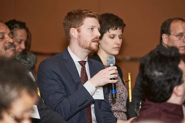 A young alumnus asks a question of President Smith.