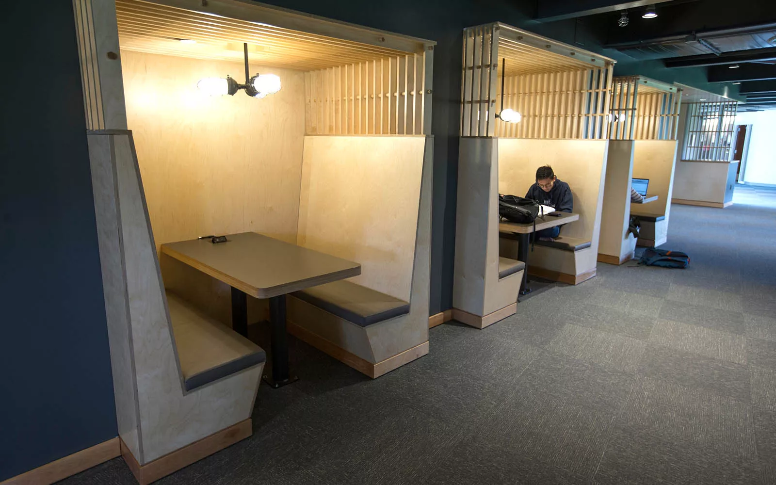 Student studies at table inside dorm lobby