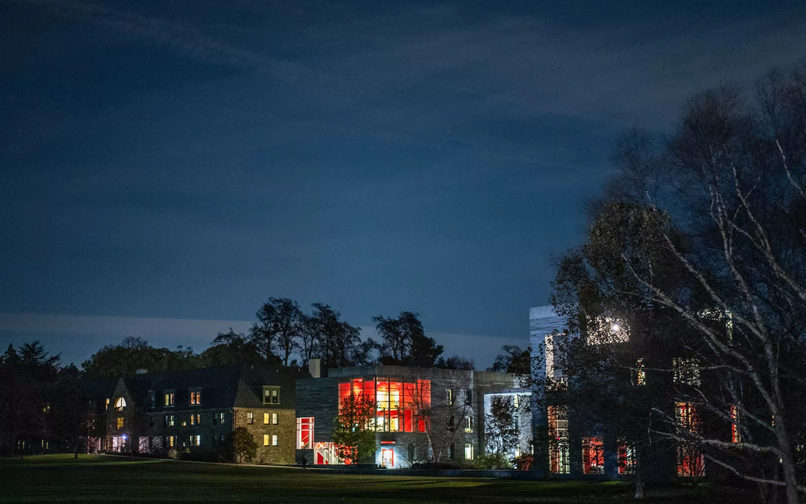 Exterior shot of dorm building at night, illuminated from within.