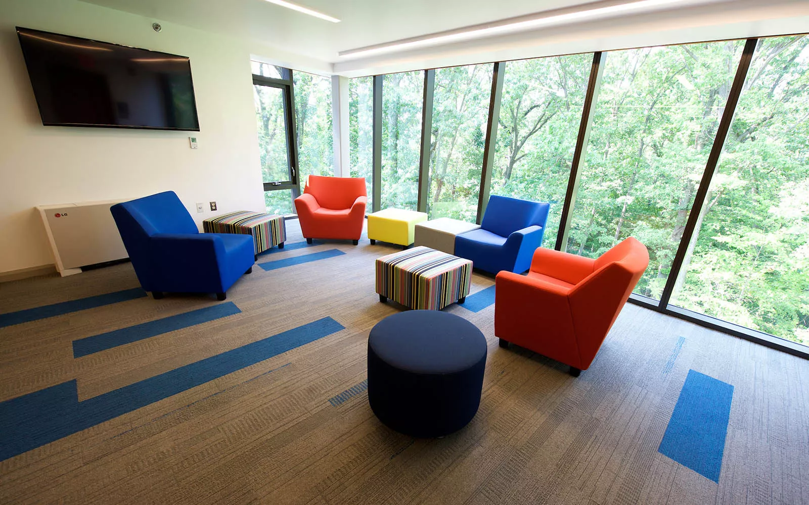 Lounge space with small couches overlooking wooded area