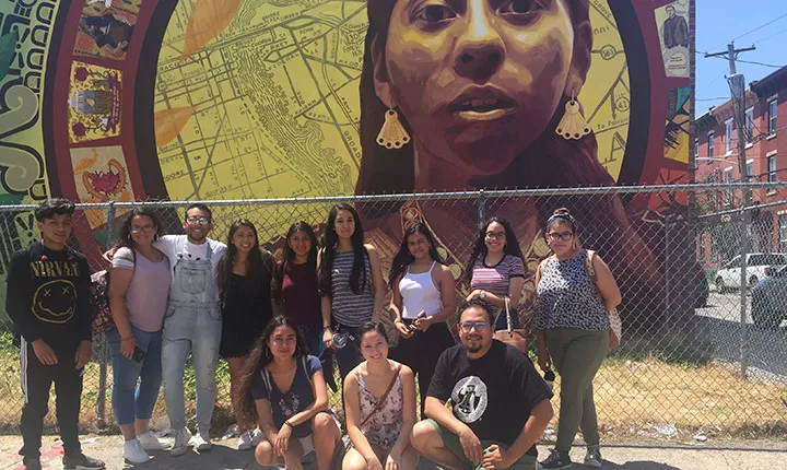 Edwin Mayorga and a group of students in front of a mural in South Philadelphia