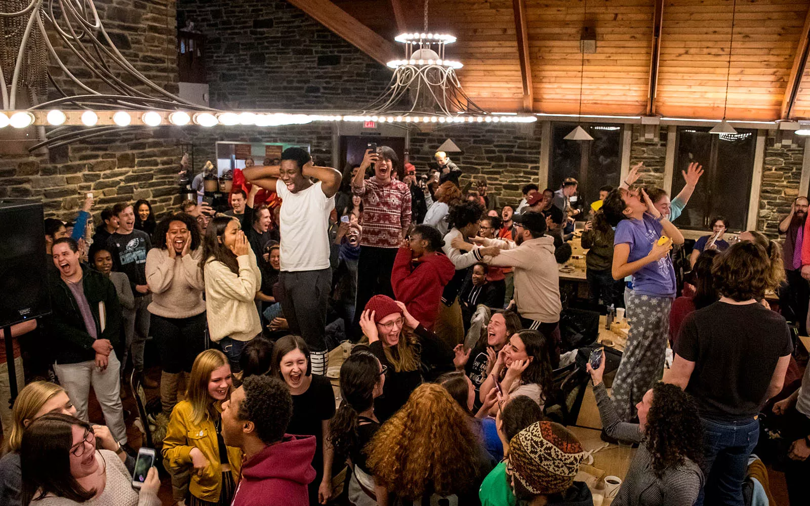 Students standing on tables in the dining hall