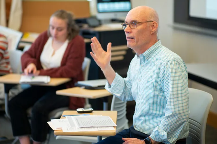 Bruce Dorsey leads class while seated at desk