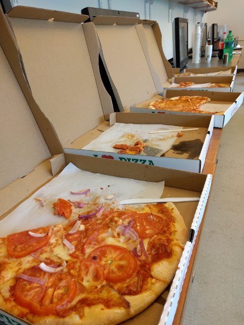 Open pizza boxes sit in a row