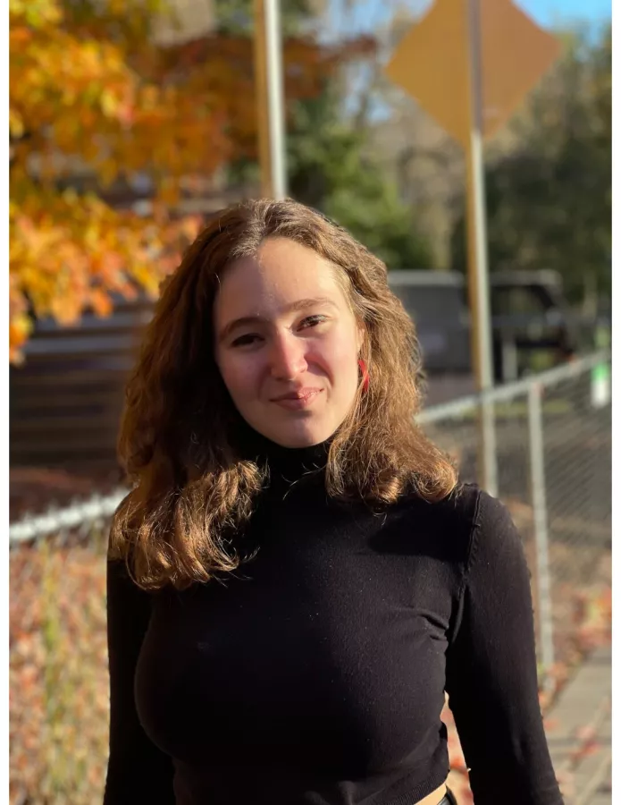 Shannon Friel stands outside in a black sweater