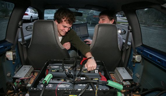 Two people working on electric car battery