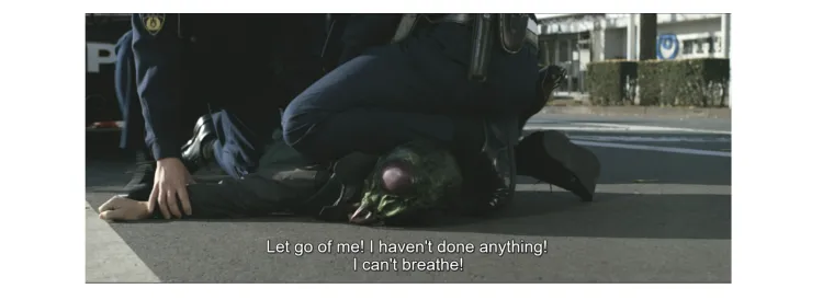Still from "Final Episode" of a kaijin being detained by the police. A police officer kneels on the kaijin's neck while the kaijin exclaims, "Let go of me! I haven't done anything! I can't breathe!"