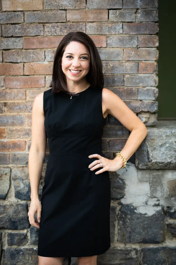 Amanda Licastro standing in front of a brick wall