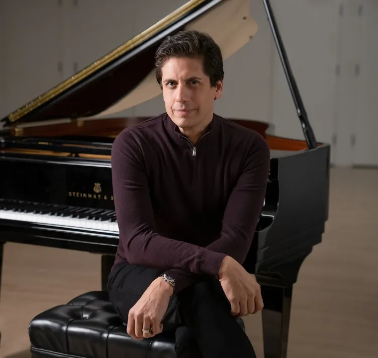 Francisco J. Núñez seated at a piano