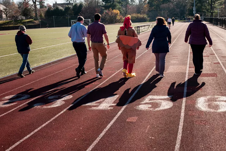 Community members walk around track for Turkey Trit