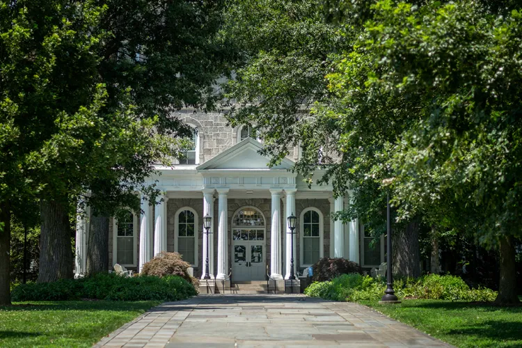 Magill Walk leading up to Parrish Hall, which is flanked by trees in full bloom