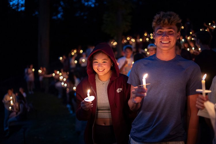 Student smile and pose with candles during First Collection