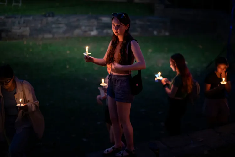 Student holds candle in amphitheater during First Collection