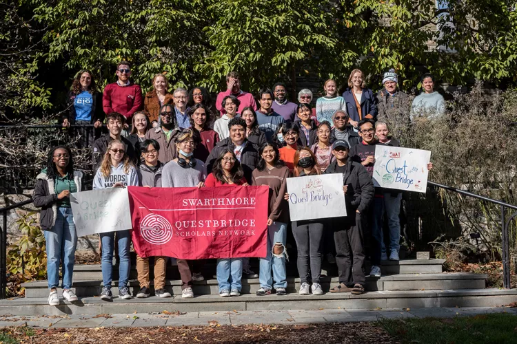 Questbridge students pose outside with banners