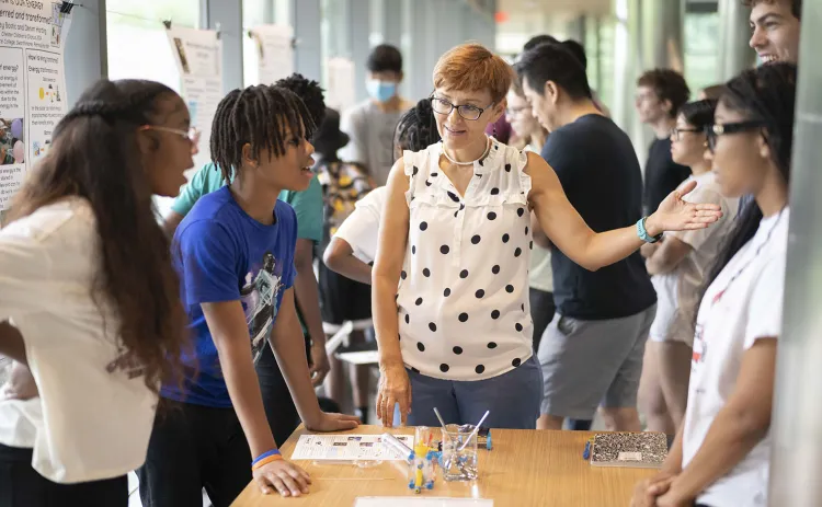 students and faculty at a poster session