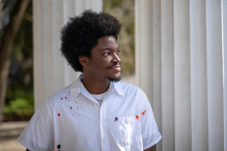 Steven Mukum ’26 stands in front of white pillars on patio of Parrish Hall