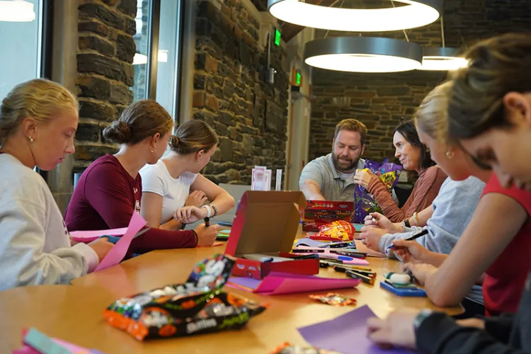 Group of people make cards and crafts inside Sharples Commons