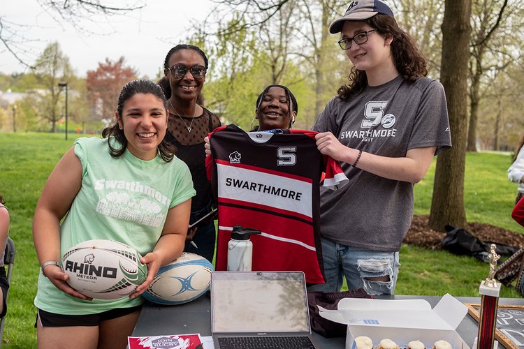 Members of the rugby team hold jerseys, ball at activities fair