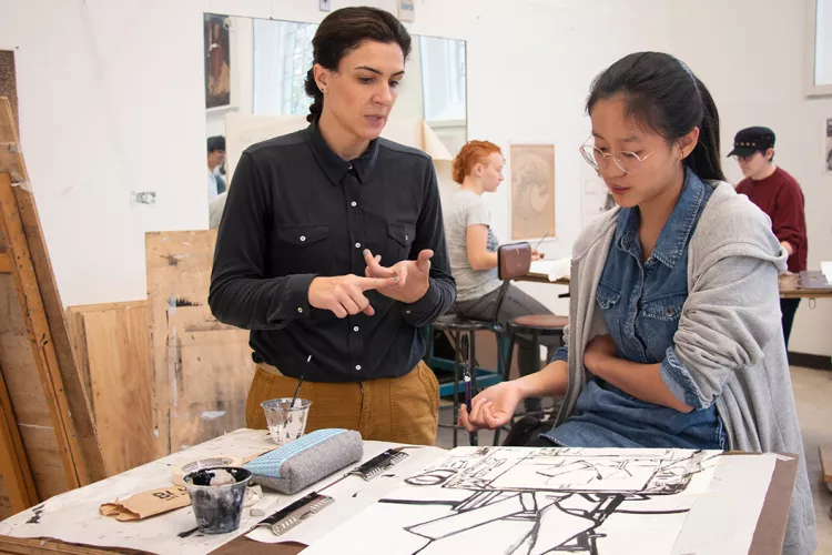 Christie DeNizio '12 helps student in painting class