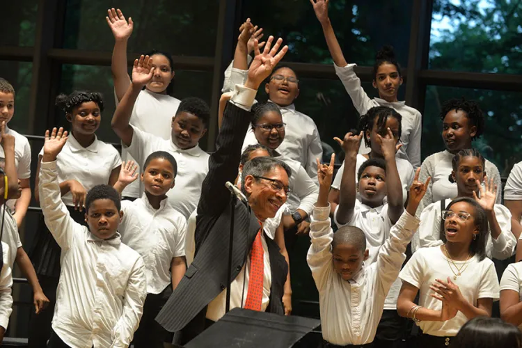 John Alston holds up four fingers as members of Chester Children's Chorus do the same