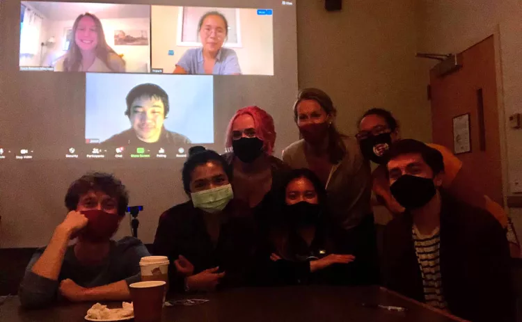 Masked students stand in front of Zoom screen