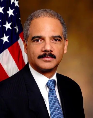 Eric Holder in front of American flag