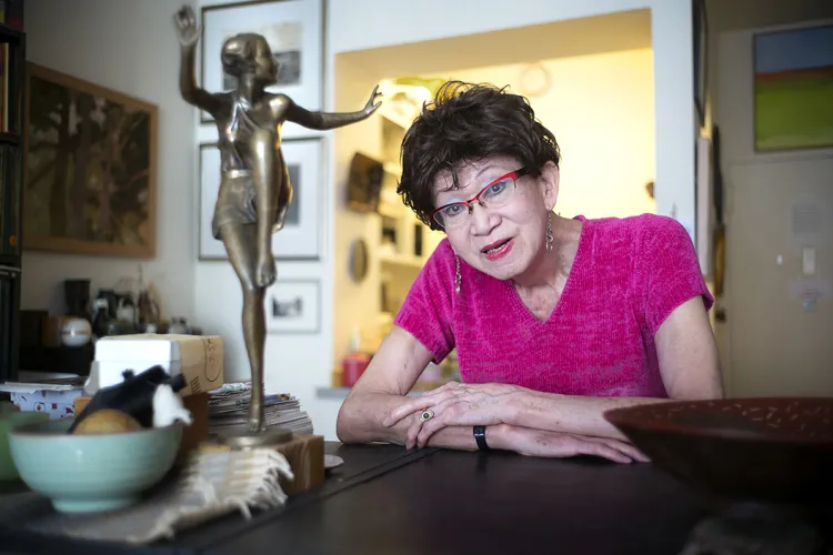 Woman wearing pink shirt sits at a table
