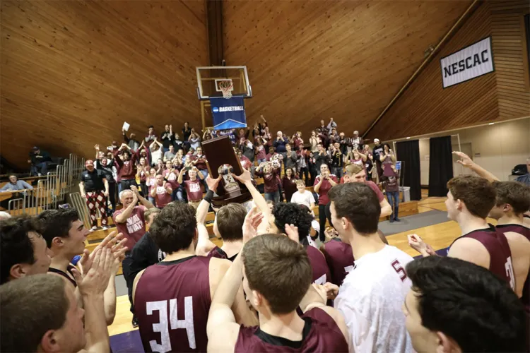 The men's basketball team celebrates with a trophy