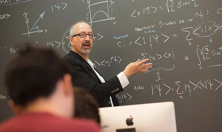 Mike Brown teaches in front of blackboard