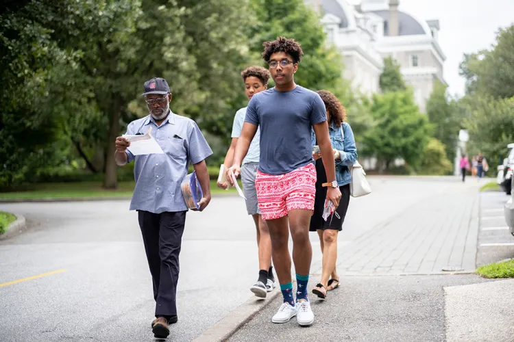 Student walks with Parrish in background